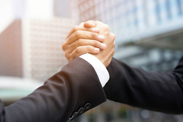 companionship hand clasping success trust, confident concept. or Closeup of a businessman hand between two colleagues on outdoor building. - Photo, Image