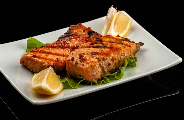 https://cdn.create.vista.com/api/media/small/277078132/stock-photo-grilled-trout-with-lemon-on-a-platter-on-a-black-table