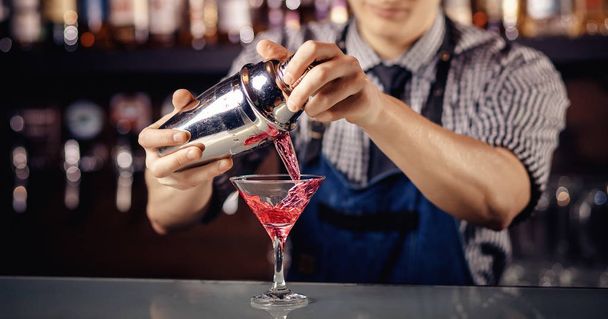 Barman prepara cóctel en coctelera con alcohol y hielo. Fondo oscuro Cantinero
 - Foto, imagen