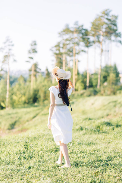  Beautiful girl in white dress and hat. Summer photo shoot in the Park at sunset. - Valokuva, kuva