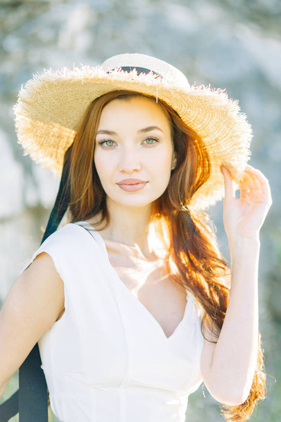 Summer photo shoot in the Park at the rocks and stones. Beautiful girl in white dress and hat.  - Foto, Imagem