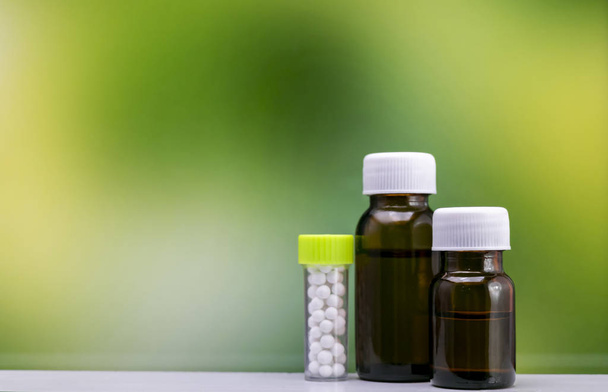 Alternatív gyógyászat koncepció homeopátiás gyógyító gyógynövények egy mozsárban és zúgnak a sztetoszkóppal együtt üveg tabletták és folyékony homeopátiás anyag - Fotó, kép