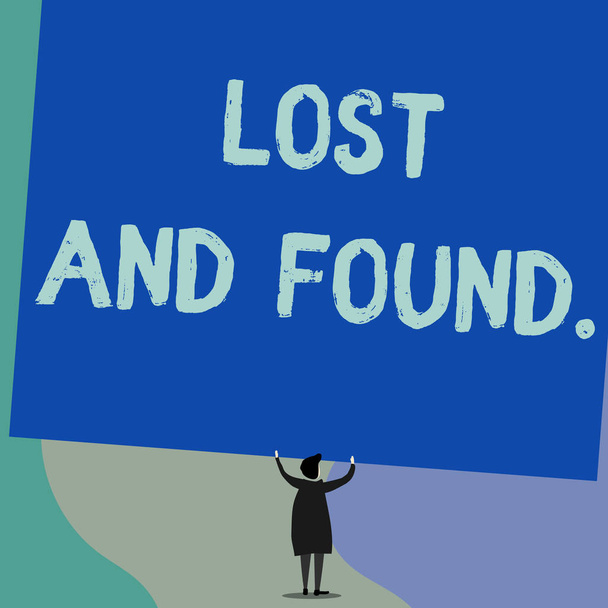 Handwriting text writing Lost And Found. Concept meaning a place where lost items are stored until they reclaimed Back view standing short hair woman dress hands up holding blank rectangle. - Photo, Image