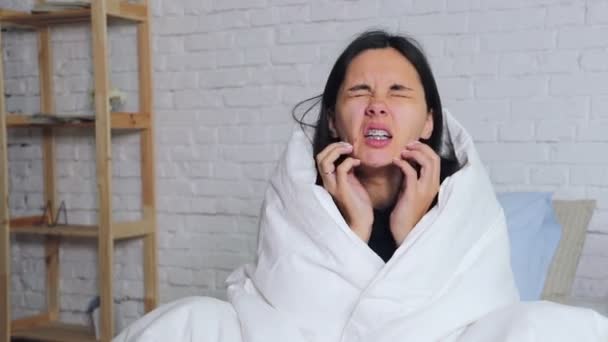 Cold flu season, runny nose. Sick girl on bed sneezing in handkerchief in bedroom - Video, Çekim