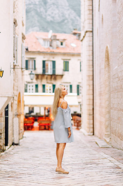 Beautiful girl with lights in Montenegro. Photo shoot on the evening and night streets of Kotor.  - Foto, Imagen