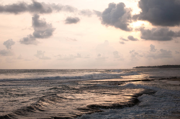 Widok linii brzegowej w Koggala, Sri Lanka, głazy na Oceanie Indyjskim o zachodzie słońca - Zdjęcie, obraz