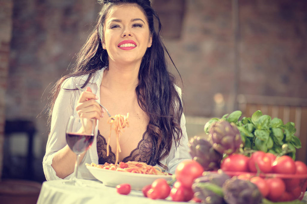 Rocznika włoskiej kobiety jedzenia włoskiego makaronu z sosem pomidorowym - Zdjęcie, obraz