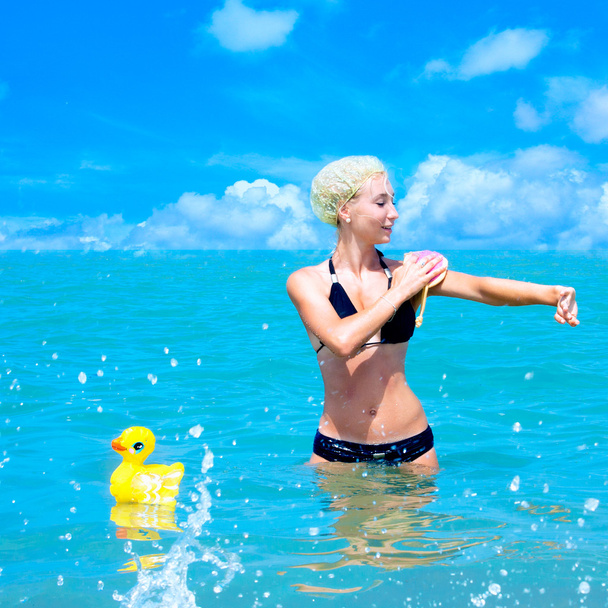 Uma menina toma um banho no mar
 - Foto, Imagem