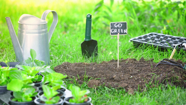 vista parcial do jardineiro em luva estuque placa de identificação com inscrição no chão no jardim
 - Filmagem, Vídeo