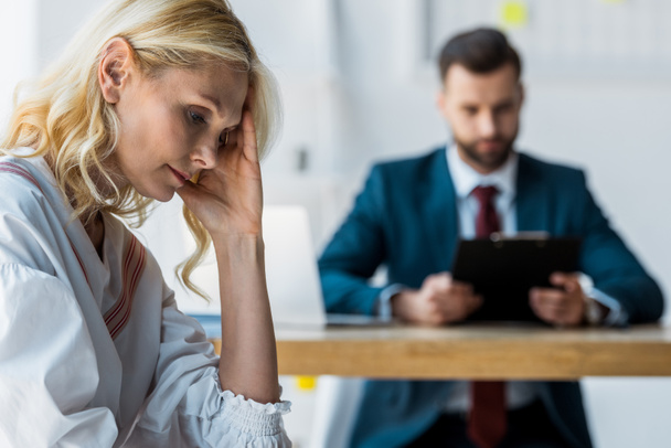 selective focus of frustrated blonde employee near recruiter in suit  - Photo, Image