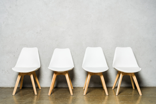 белые стулья рядом с серой бетонной стеной с копировальным местом в офисе
  - Фото, изображение
