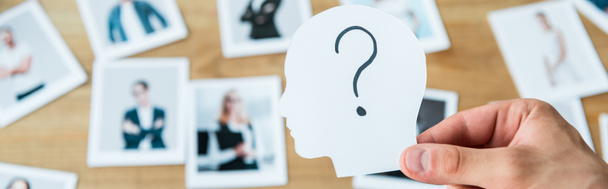panoramic shot of man holding paper with human head and question mark near photos  - Photo, Image
