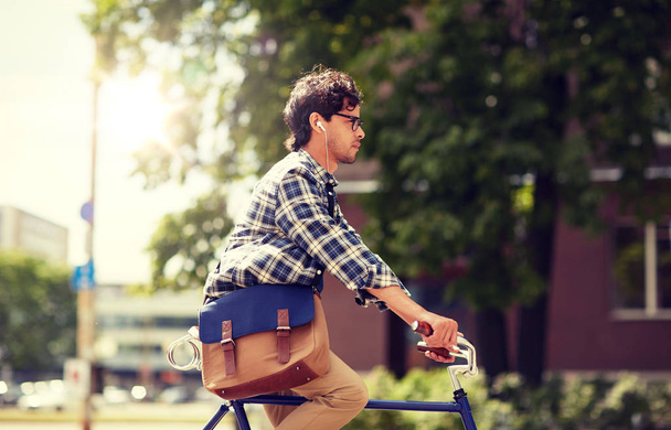 young hipster man with bag riding fixed gear bike - Фото, зображення