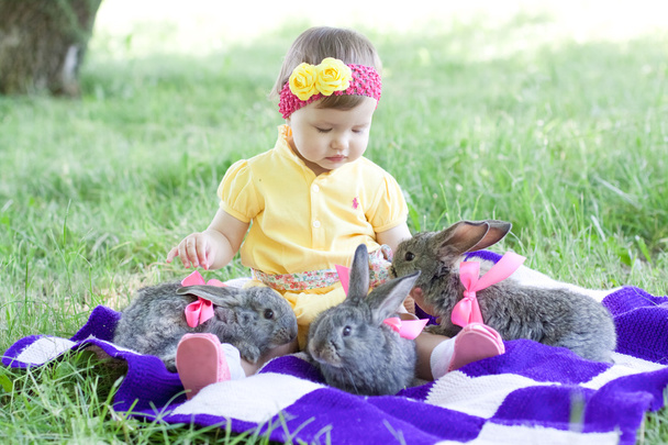 Cute baby with bunnies outdoors - Photo, Image