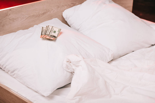 selective focus of dollar banknotes on clean pillows on bed - Photo, Image