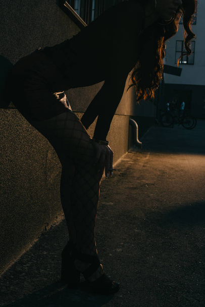 corte vista de mulher em saia vermelha e malha meias de pé parede
 - Foto, Imagem