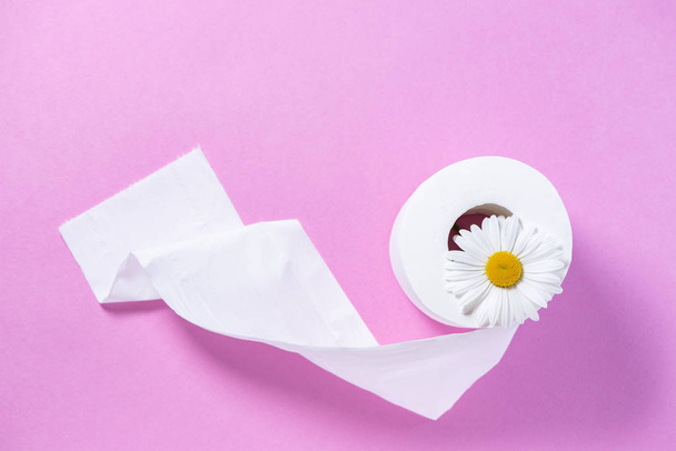 Белая перфорированная туалетная бумага с запахом и маргариткой на розовом
 - Фото, изображение
