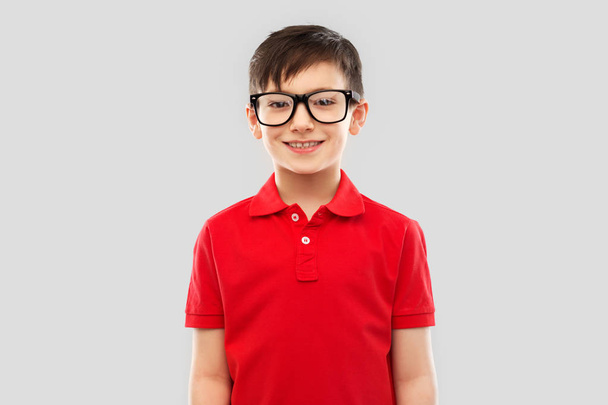 retrato de niño sonriente en gafas y camiseta roja
 - Foto, imagen
