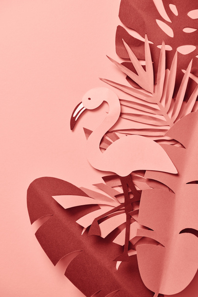 вид зверху на паперовий фламінго серед листя пальми на рожевому фоні
 - Фото, зображення