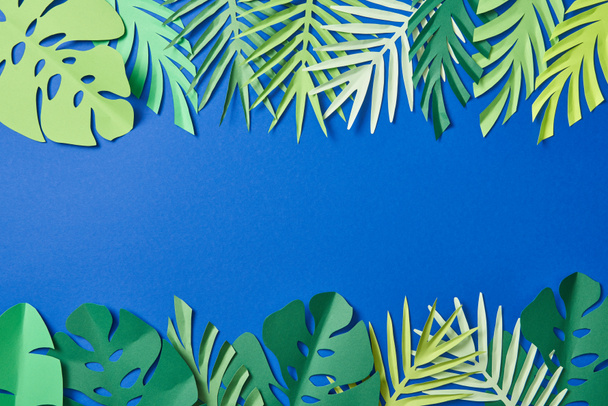 top view of green exotic leaves on blue background with copy space - Foto, Imagem
