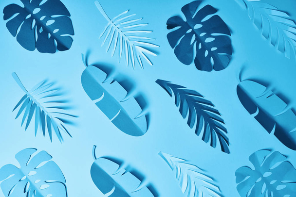 patrón sin costuras de hojas de palma cortadas de papel minimalista azul sobre fondo azul
 - Foto, Imagen