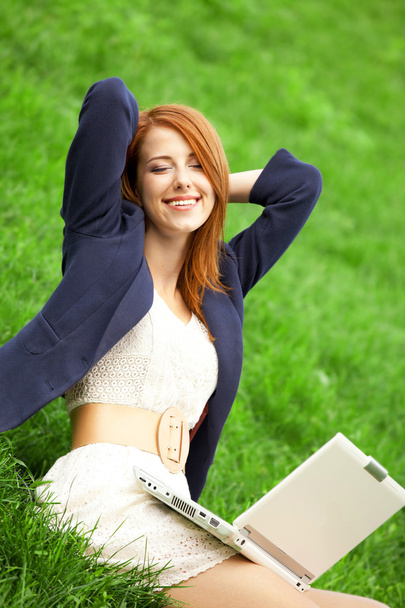 Redhead girl at green grass with notebook - Фото, изображение