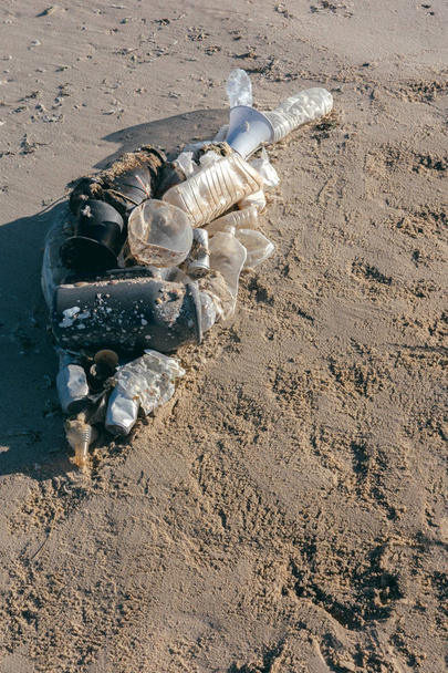 Kala muoto makaa rannalla hiekkaa merten roskat. Muovien saastumisen käsite
. - Valokuva, kuva