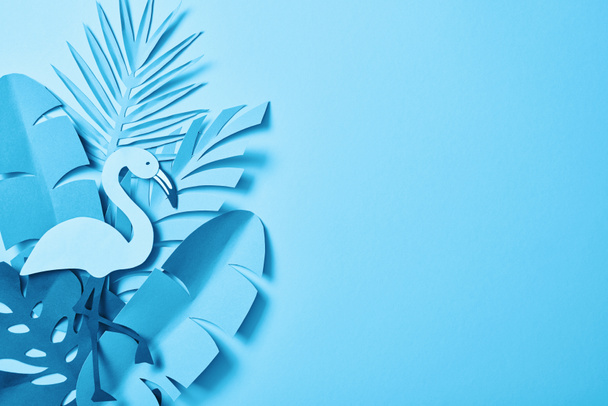 top view of blue minimalistic paper cut palm leaves on blue background with copy space - Zdjęcie, obraz