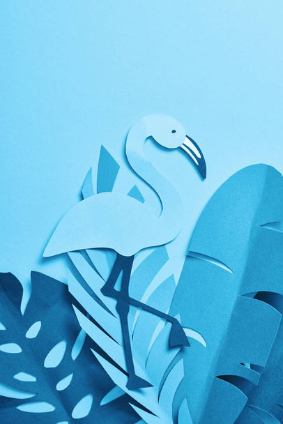 верхний вид голубой бумаги срезать пальмовые листья и фламинго на голубом фоне
 - Фото, изображение