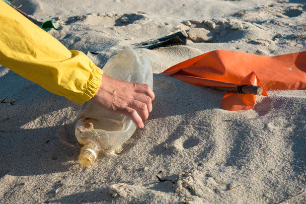 Femme ramassant des ordures et des plastiques nettoyant la plage avec un sac poubelle. Militant bénévole pour l'environnement contre le changement climatique et la pollution des océans
. - Photo, image