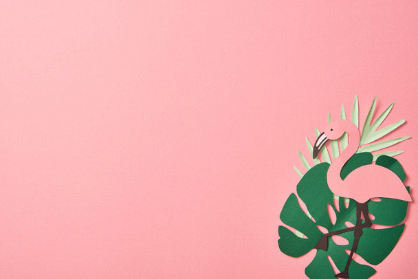 top view of paper cut flamingos on green palm leaves on pink background with copy space - Foto, immagini