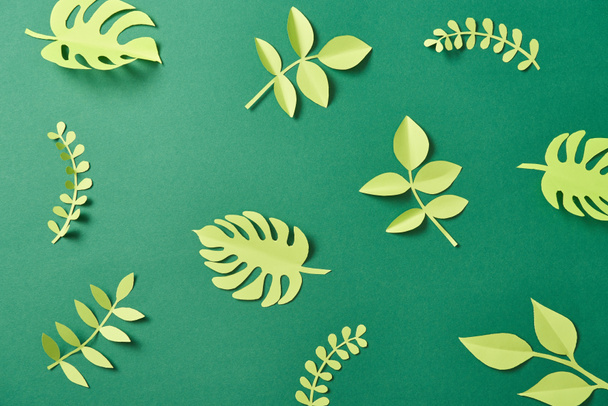 pattern of exotic paper cut palm leaves on green background with copy space - Fotó, kép