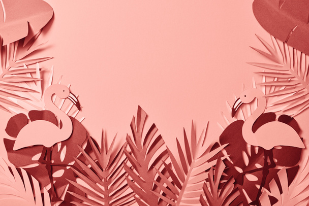 top view of pink exotic paper cut palm leaves and flamingos on pink background with copy space - Photo, Image