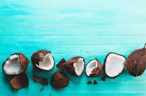Chopped coconut on a blue wooden background - Фото, изображение