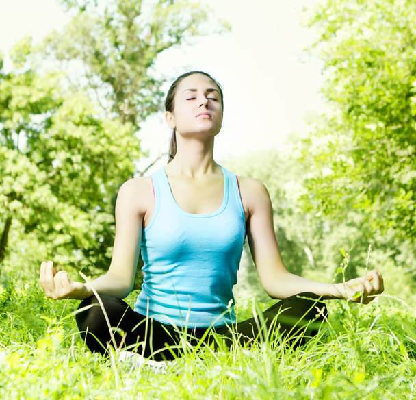 fiatal nő meditál a parkban - Fotó, kép