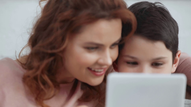mãe e filho sorrindo e usando tablet digital juntos em casa
 - Filmagem, Vídeo