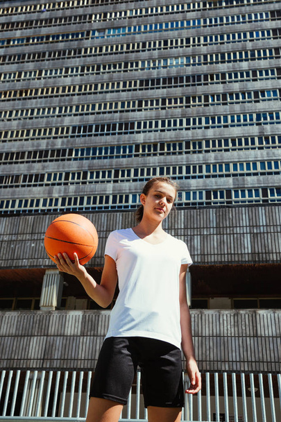 Young female basketball player in an urban court - Φωτογραφία, εικόνα