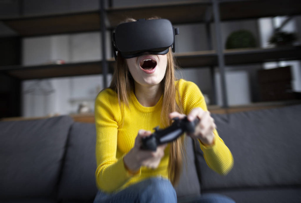 Cute girl plays the game on the console. Happy young woman using - Photo, Image
