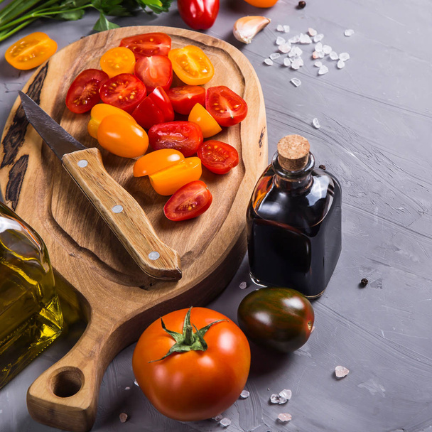 Спелые помидоры для приготовления овощного блюда на сером фоне
 - Фото, изображение