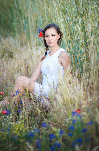 genç kız vahşi flowers.beautiful kadın zevk papatya alan, çelenk ile altın buğday field.portrait güzel sarışın kızın güzel kızın rahatlatıcı açık, uyum kavramı - Fotoğraf, Görsel