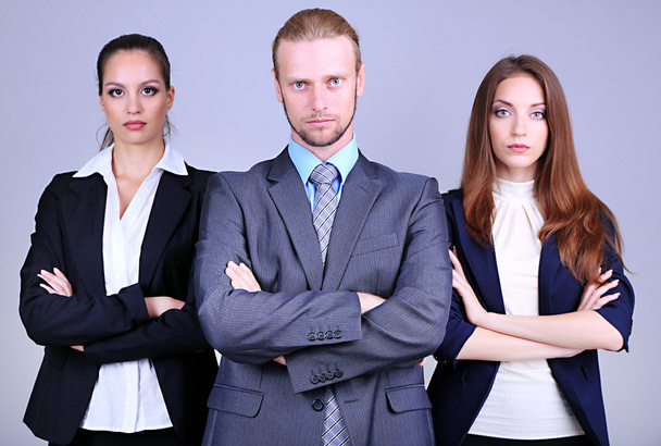 Команда бизнесменов, стоящая в ряд на сером фоне
 - Фото, изображение