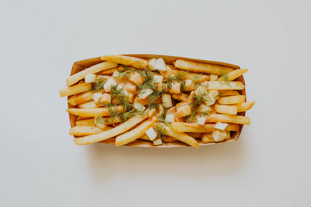 top view of tasty french fries with dill in box on grey - Zdjęcie, obraz