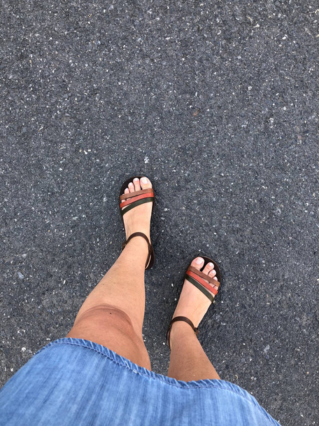 Close-up voeten van een vrouw die sandalen draagt - Foto, afbeelding