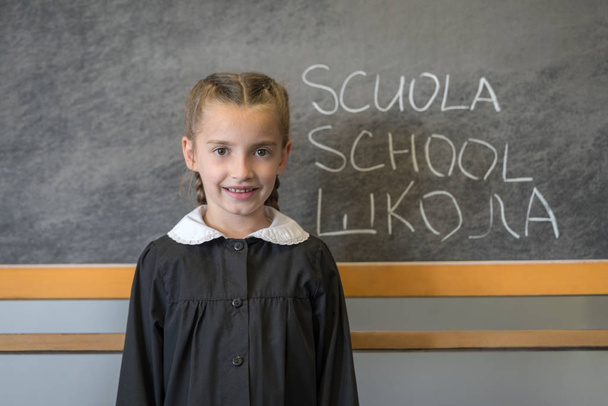 Δημοτικό σχολείο κορίτσι μαθήτρια με στολή στον πίνακα  - Φωτογραφία, εικόνα