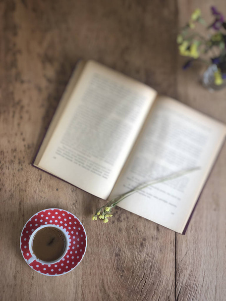 starą książkę i filiżankę kawy na drewnianym stole - Zdjęcie, obraz