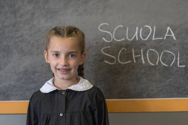 Elementary school student posing in uniform in a class setting - Photo, Image