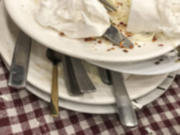 Θαμπό φόντο με αποφάγια και βρώμικα πιάτα στο τραπέζι - Φωτογραφία, εικόνα