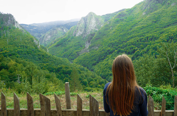 Girl looks into the distance. The mountains are covered with greenery. Montenegro - Foto, afbeelding