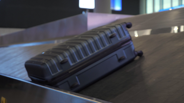 Grey suitcase on luggage conveyor belt in the airport terminal. - Footage, Video