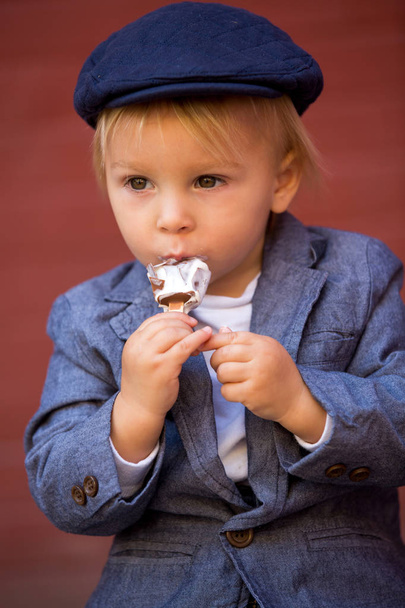 Cute child, boy in vintage cloths, eating lollipop ice cream, si - Фото, зображення
